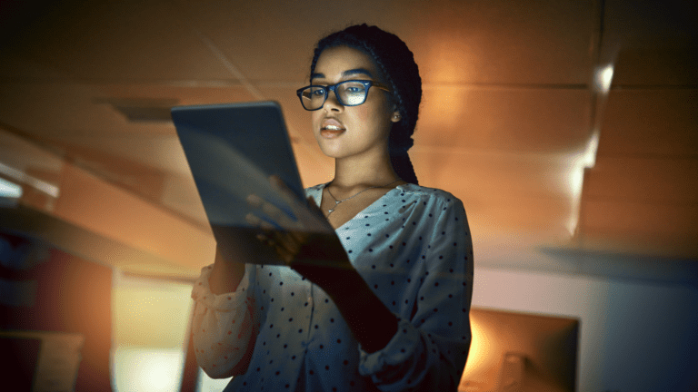 Mulher jovem utilizando tablet em ambiente corporativo, simbolizando investimento das empresas brasileiras em tecnologia e inovação.