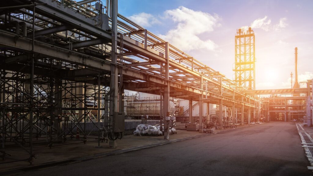 Parque industrial com tubulações e estruturas metálicas ao pôr do sol, simbolizando a nova política industrial brasileira do MCTI.