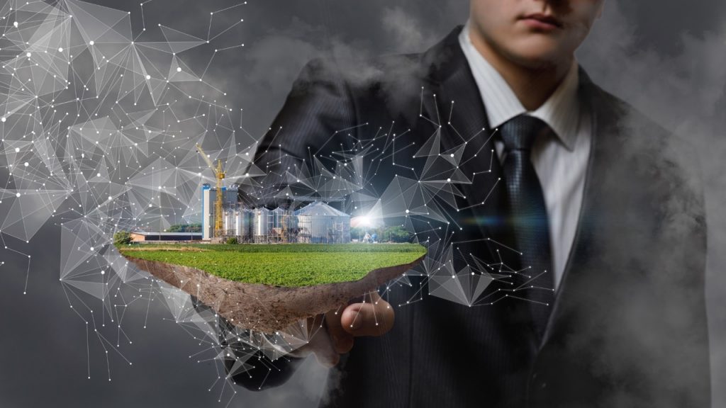 Executivo segurando maquete flutuante de parque industrial com malha de conexões digitais, simbolizando investimento de R$ 180 milhões do MCTI e Embrapii em Centros de Competência em tecnologia.