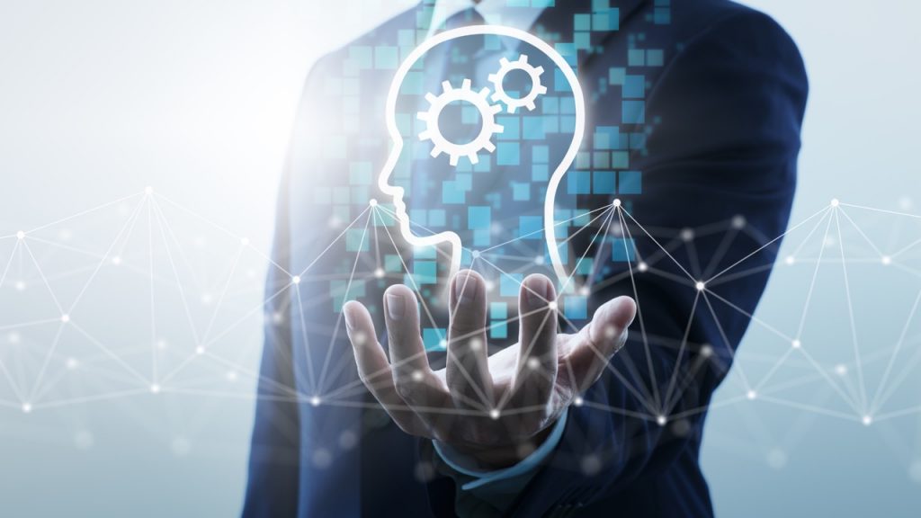 Executivo exibindo holograma de cabeça com engrenagens e rede de conexões, simbolizando os Centros de Competência; MCTI e Embrapii investem R$ 180 milhões em tecnologia e inovação no Brasil.