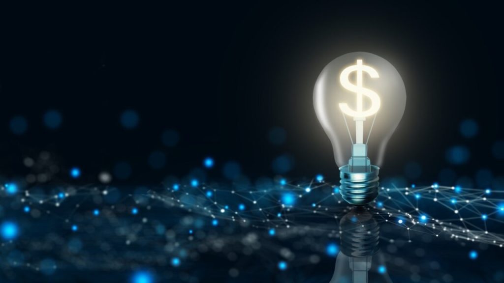 Lâmpada com símbolo de cifrão sobre rede digital; financiamento do BNDES mais barato para inovação e digitalização.