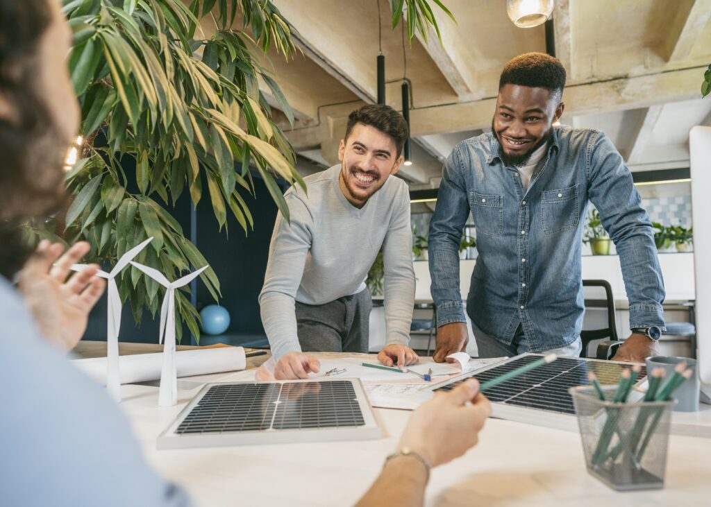Empreendedores em coworking sorrindo durante reunião — nova linha de crédito para startups de São Paulo e incentivo a projetos sustentáveis.