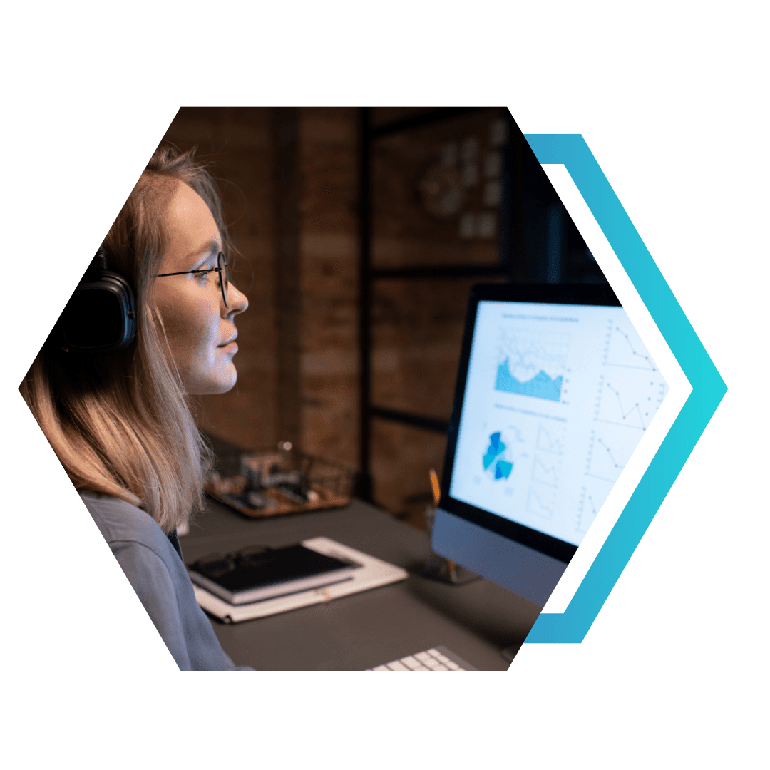 Profissional com fones e óculos analisando gráficos em um monitor, em ambiente de escritório — identificar oportunidades a partir de dados