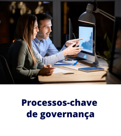 Gestores analisam gráfico de desempenho em monitor para definir processos-chave de governança