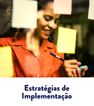 Mulher sorrindo escreve em um post-it, cercada por notas adesivas coloridas em painel de brainstorming — estratégias de implementação.
