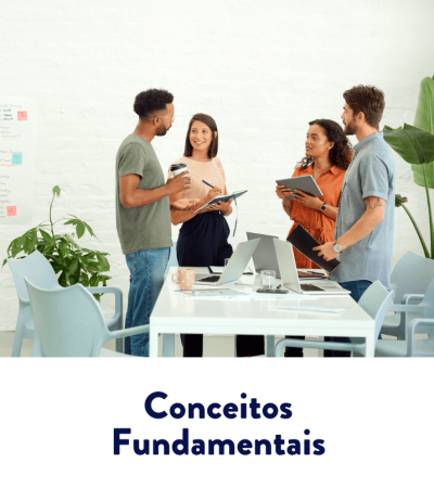 Quatro colegas em pé ao redor de uma mesa com laptops e tablets, conversando e anotando em um escritório claro — conceitos fundamentais.